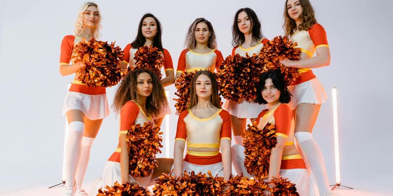 Group of people in a bright studio performing a fluid cardio sequence.